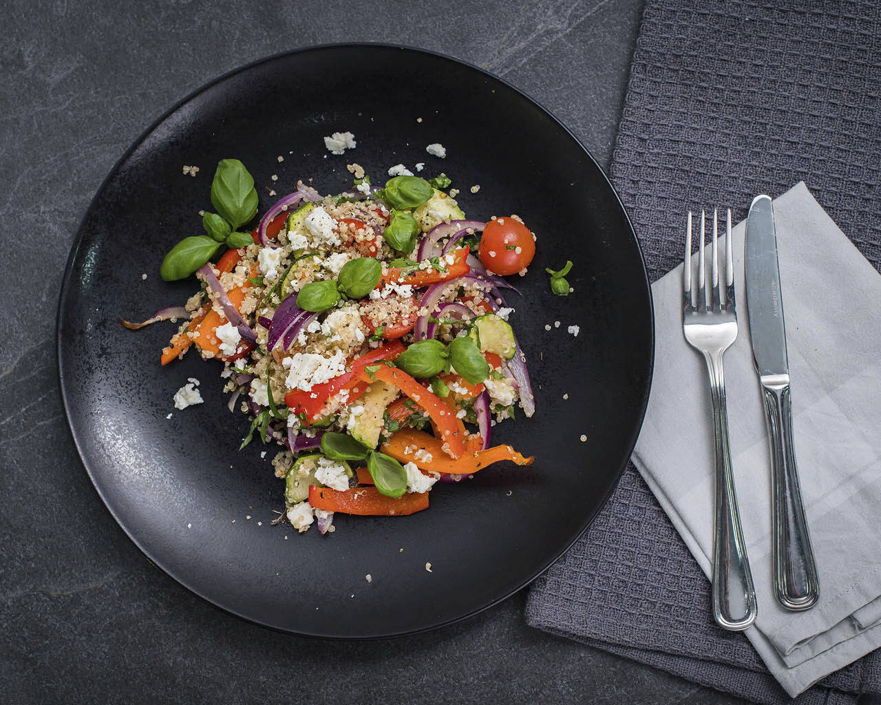 pic of quinoa salad on a black plate