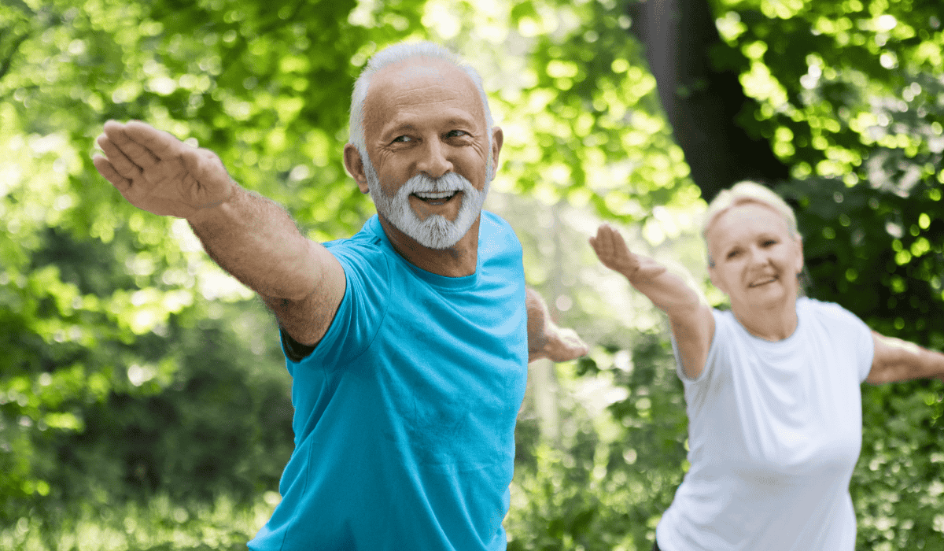 Older man and woman doing exercise in the park
