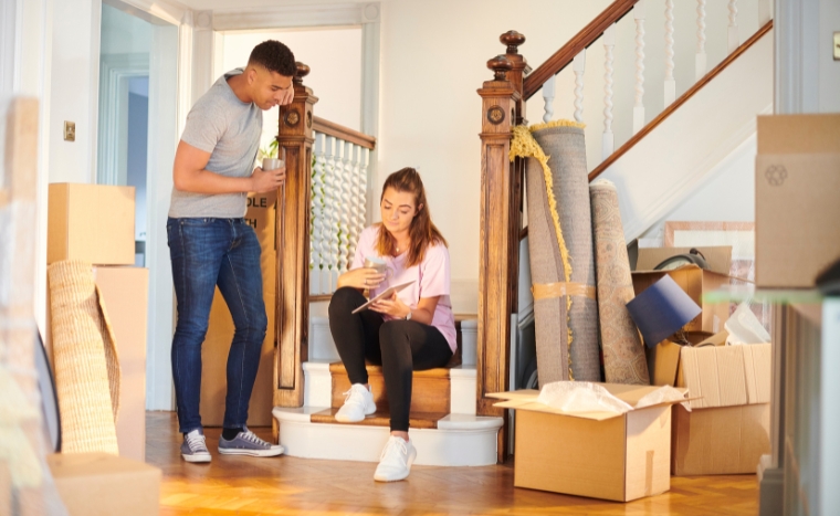 Home insurance couple standing beside stairs