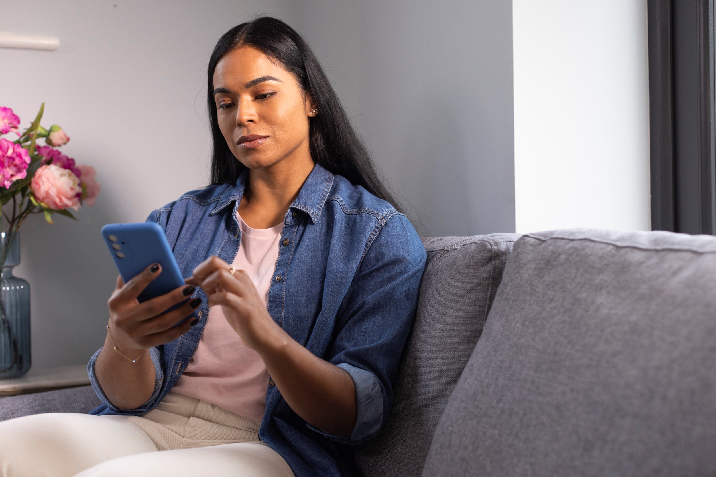 Woman looking at phone on couch